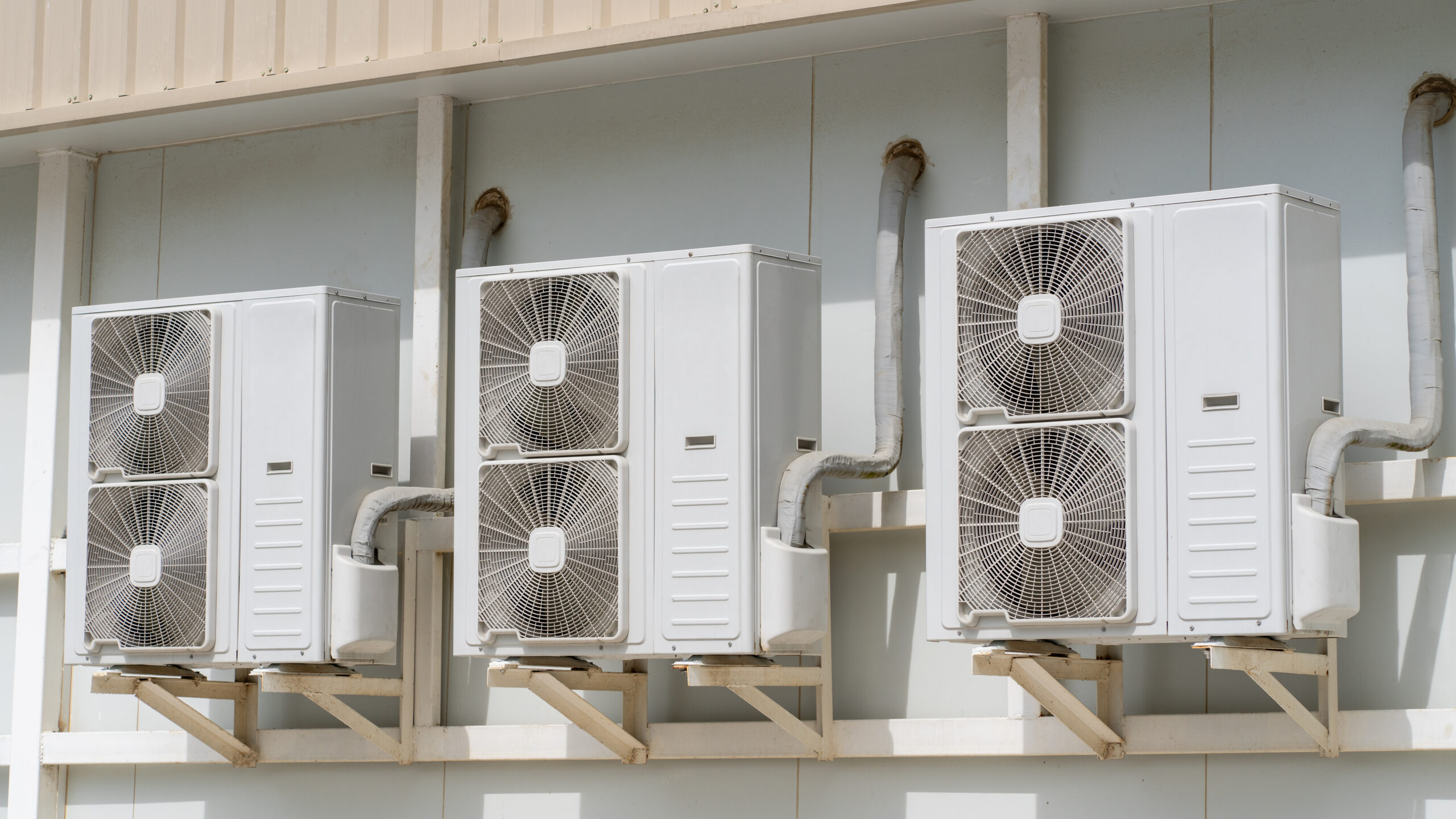 Outdoor air conditioning condenser units mounted on a wall.