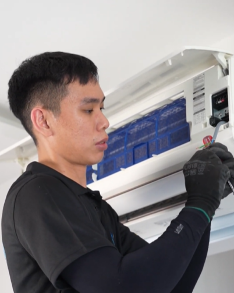 Technician performing thorough cleaning of air conditioning unit interior